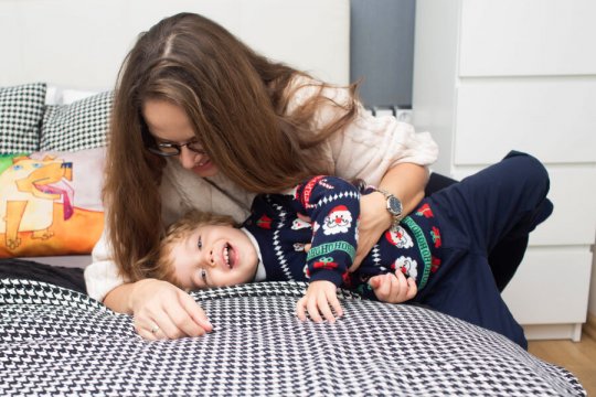 sesja lifestylowa, sesja rodzinna w domu, mama i syn w trakcie łaskotek na łóżku, zdjęcia rodzinne