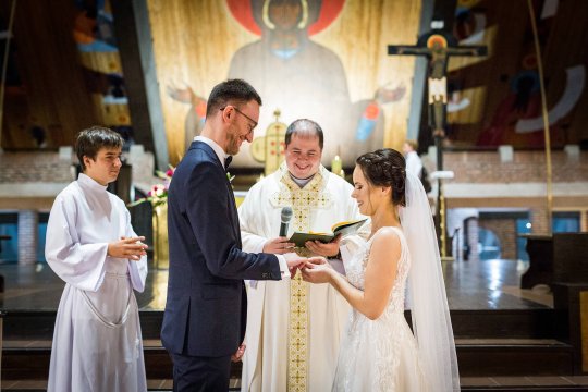 para młoda składa sobie przysięgę małżeńską, zdjęcie ślubne z kościoła podczas nakładania obrączek