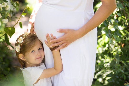sesja ciążowa w plenerze, dziecko przytulające brzuszek ciążowy