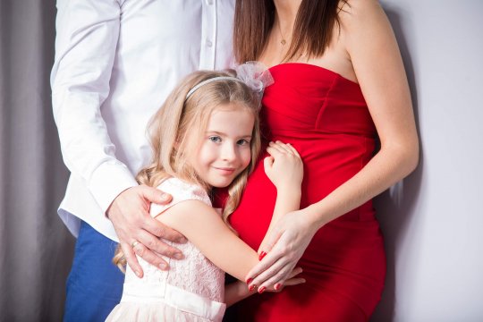 dziewczynka przytulająca brzuszek ciążowy, starsza siostra przytula brzuch ciążowy, sesja ciążowa, rodzina, ciąża